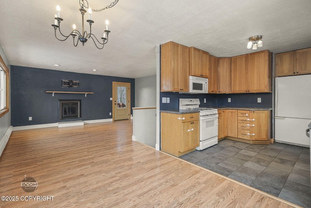 kitchen featuring dark wood-type flooring, white appliances, and a chandelier