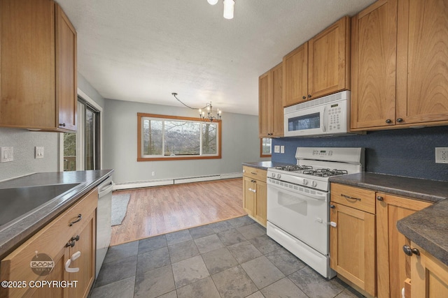 kitchen with a baseboard heating unit, a notable chandelier, sink, white appliances, and a textured ceiling