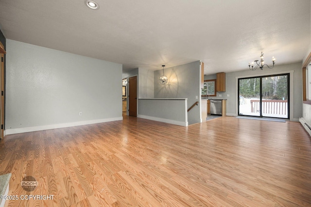 unfurnished living room with light wood-type flooring and a chandelier