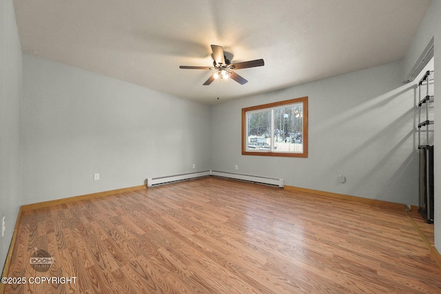 empty room featuring ceiling fan, a baseboard heating unit, and light hardwood / wood-style floors