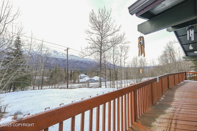 snow covered deck with a mountain view