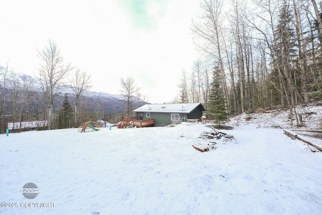 yard layered in snow featuring a wooden deck