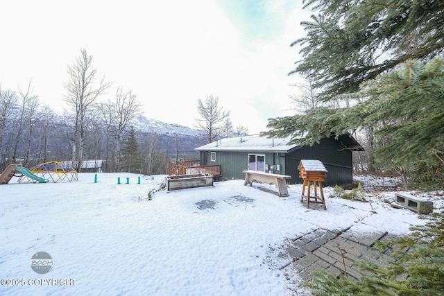 snowy yard featuring a deck with mountain view