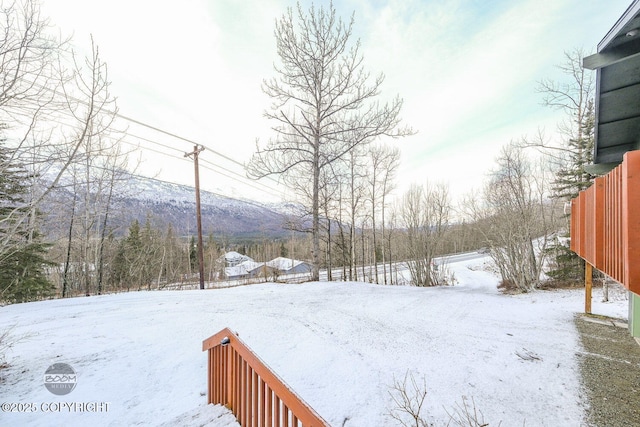 yard layered in snow with a mountain view