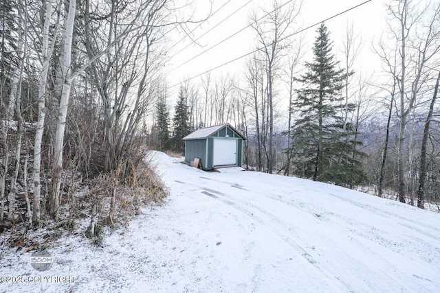 yard covered in snow featuring an outdoor structure and a garage