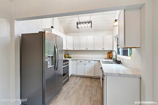 kitchen with white cabinetry, appliances with stainless steel finishes, light wood-type flooring, lofted ceiling, and sink