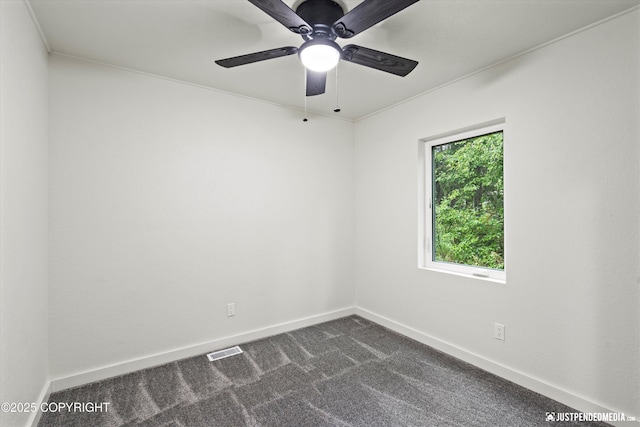 unfurnished room with ceiling fan and dark carpet