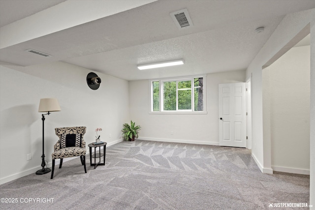 unfurnished room with light colored carpet and a textured ceiling