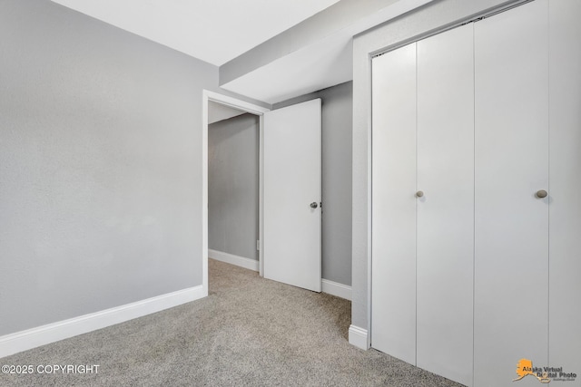 unfurnished bedroom with light carpet and a closet