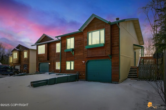 back house at dusk featuring a garage