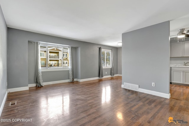 spare room with dark hardwood / wood-style floors, sink, and ceiling fan