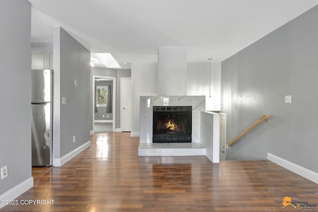 unfurnished living room with dark wood-type flooring and a premium fireplace