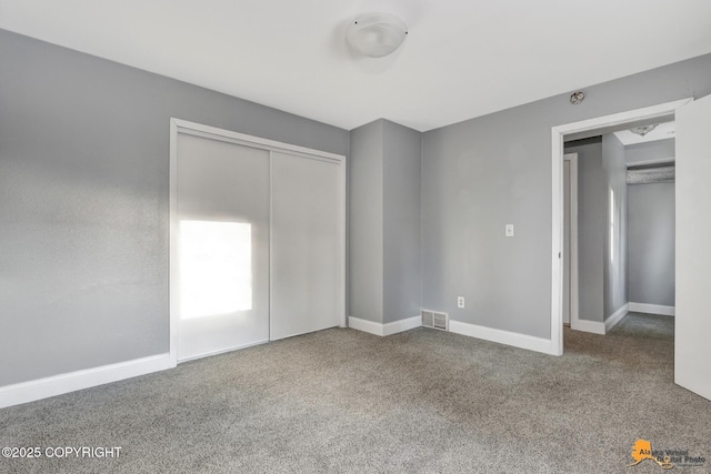 unfurnished bedroom featuring carpet floors and a closet