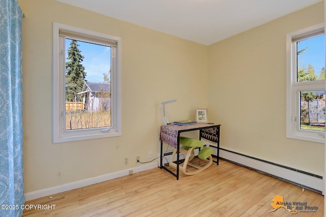 unfurnished office with a baseboard radiator, hardwood / wood-style flooring, and baseboards