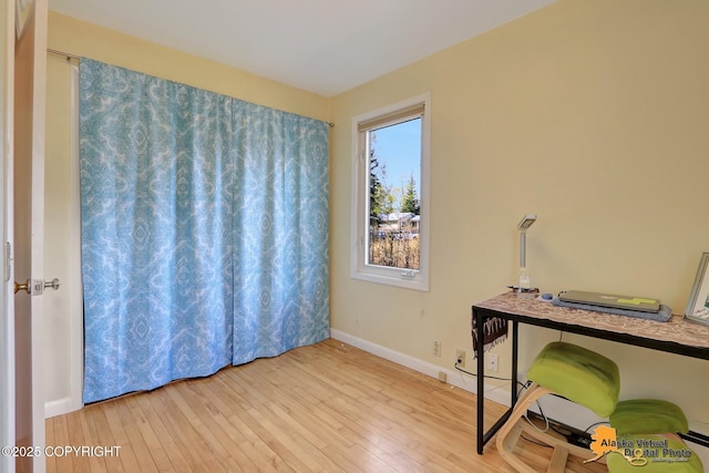 home office with hardwood / wood-style flooring and baseboards