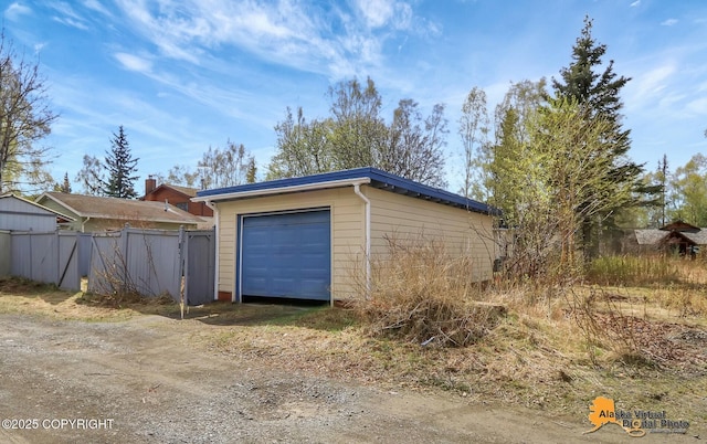 garage with driveway and fence