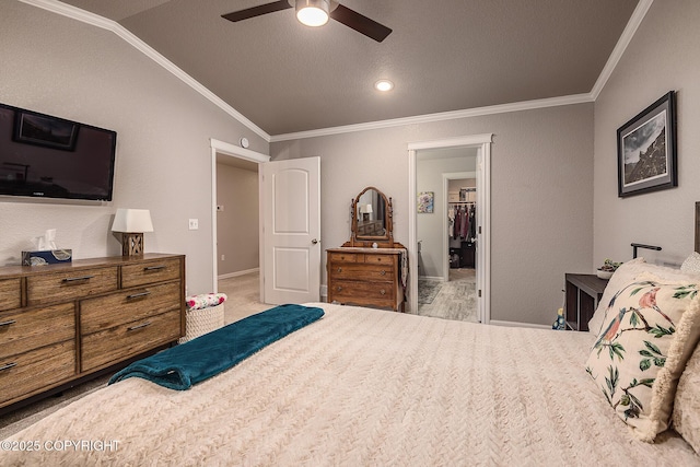 bedroom with ceiling fan, ornamental molding, a textured ceiling, a spacious closet, and vaulted ceiling