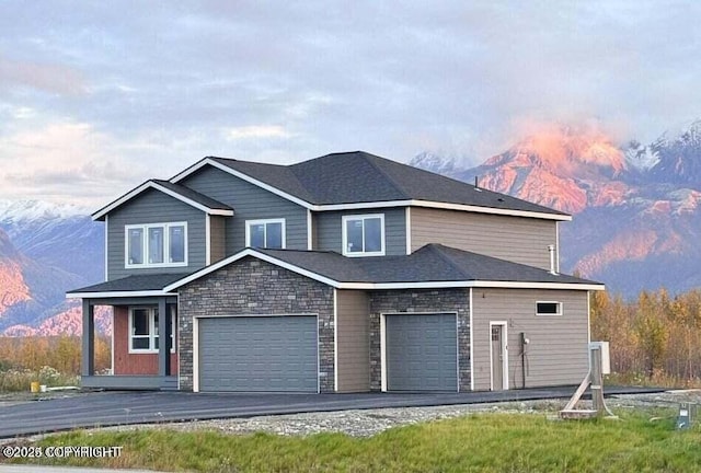 traditional-style house featuring stone siding, roof with shingles, and a mountain view