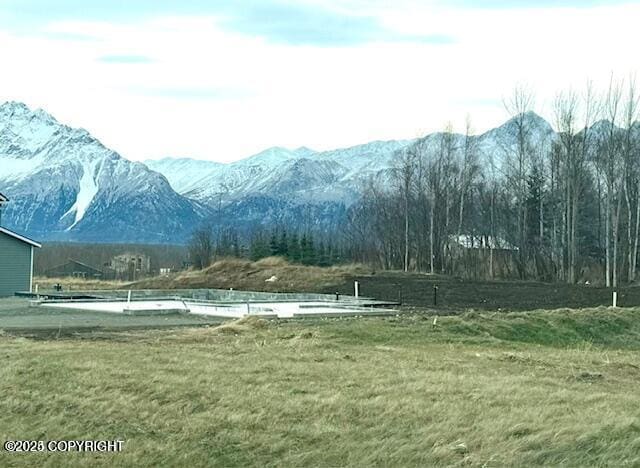 view of home's community with a mountain view and a lawn