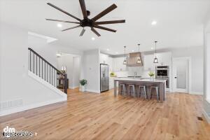 kitchen featuring a center island, pendant lighting, stainless steel appliances, light countertops, and white cabinetry