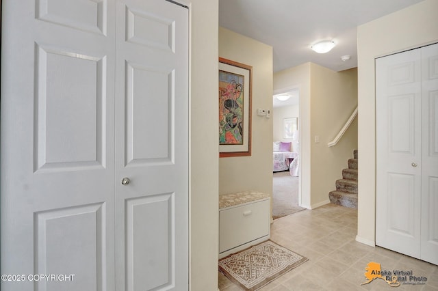 hallway with stairs and baseboards