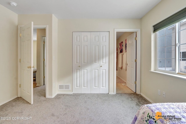 unfurnished bedroom with visible vents, baseboards, a closet, and carpet flooring