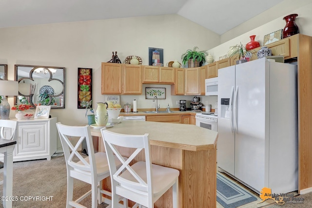 kitchen featuring light brown cabinets, a sink, white appliances, light countertops, and light colored carpet