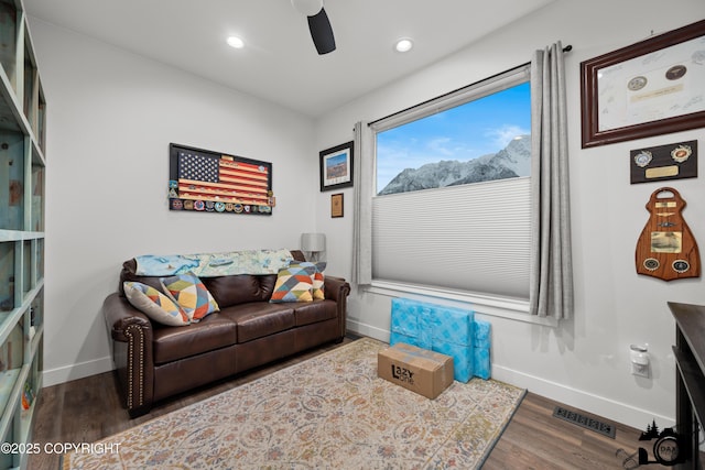 living room with dark wood-type flooring and ceiling fan