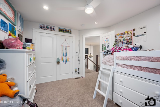 carpeted bedroom with ceiling fan and a closet