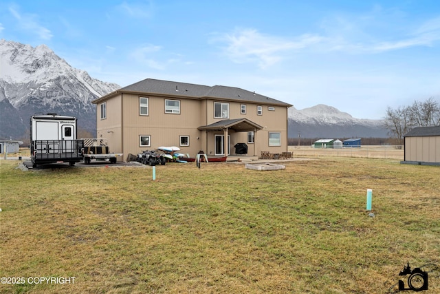 back of property with a shed, a lawn, and a patio area