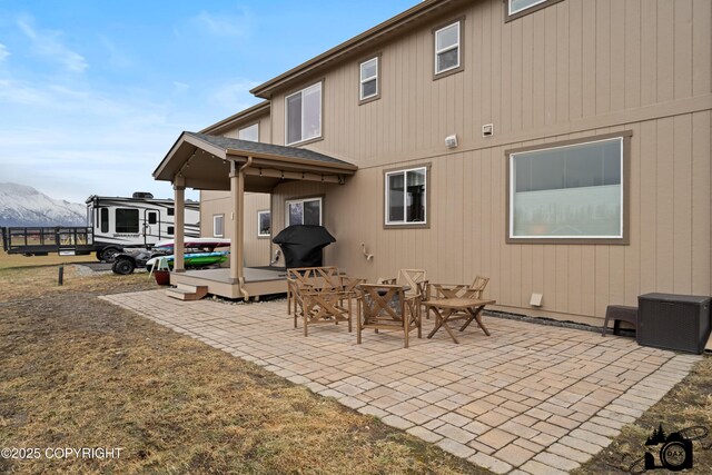 rear view of house featuring a mountain view and a patio