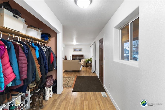 corridor featuring light hardwood / wood-style flooring and a textured ceiling