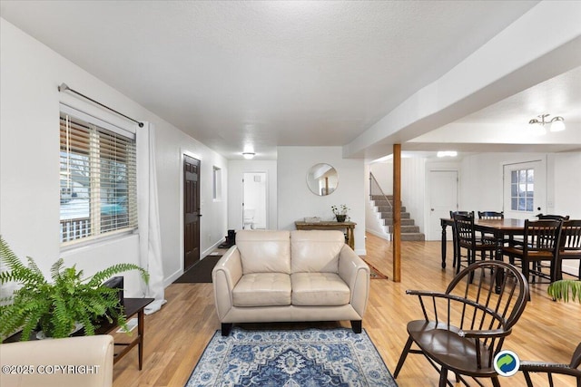 living room featuring a wealth of natural light, a textured ceiling, and light wood-type flooring