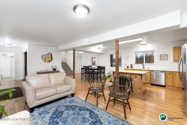 living room featuring light hardwood / wood-style flooring, a textured ceiling, and indoor bar