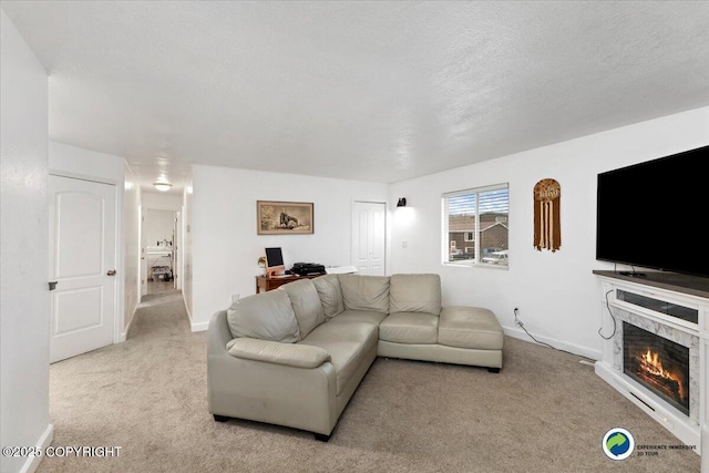 carpeted living room with a stone fireplace and a textured ceiling