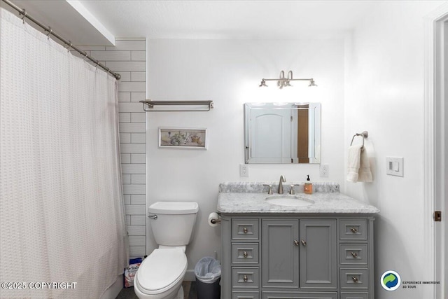 bathroom featuring vanity, walk in shower, and toilet