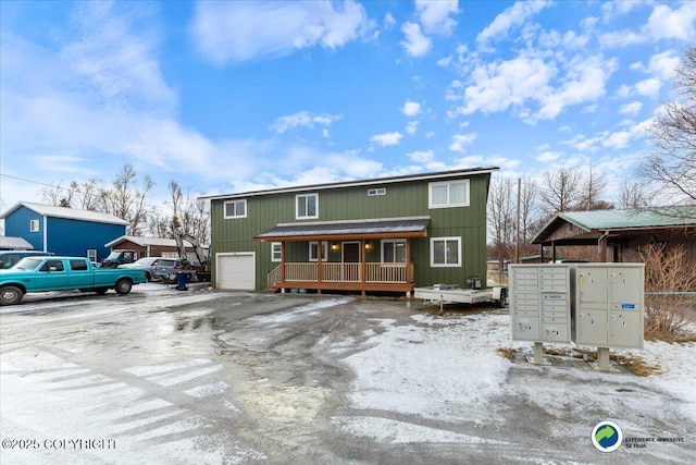 snow covered rear of property with a garage