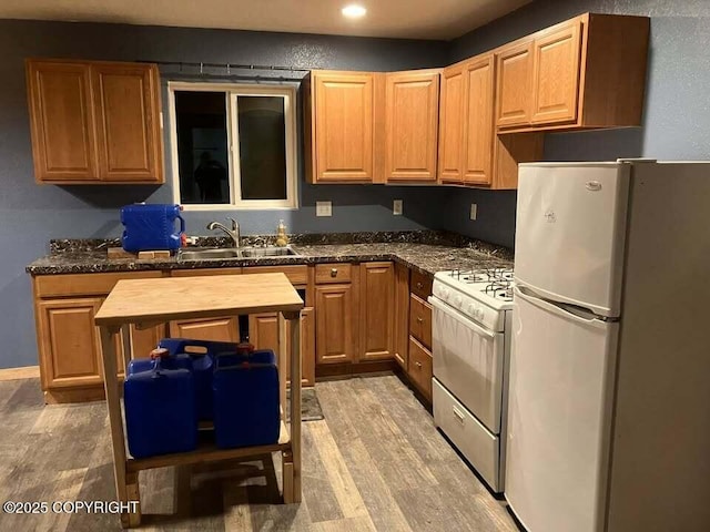 kitchen featuring sink, white appliances, light hardwood / wood-style flooring, and butcher block counters