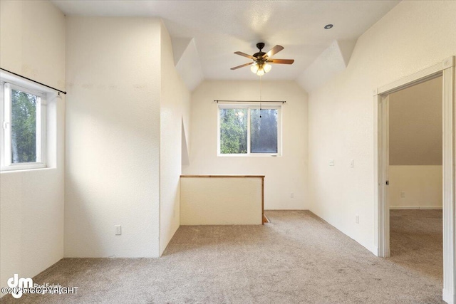 carpeted empty room with vaulted ceiling and ceiling fan