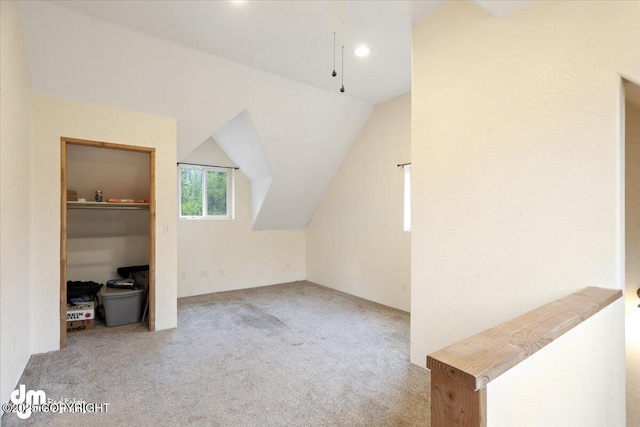 additional living space with light colored carpet and lofted ceiling