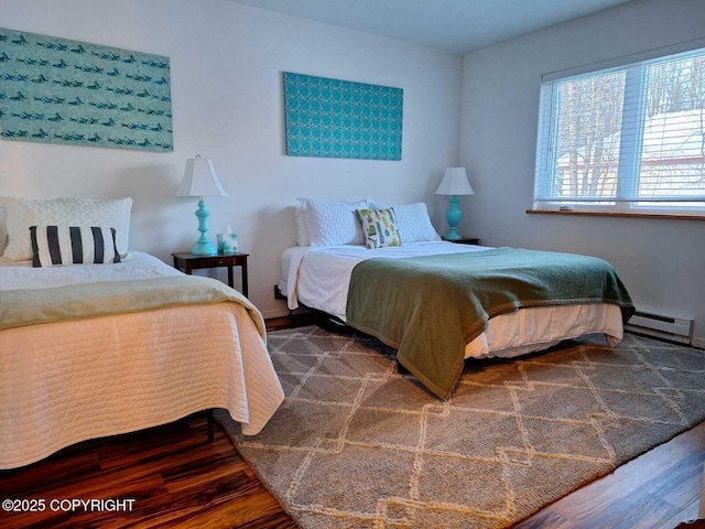 bedroom featuring dark wood-type flooring and a baseboard heating unit