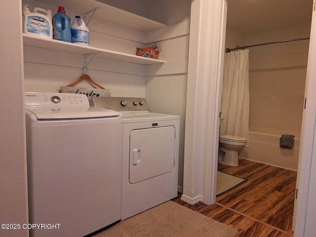 clothes washing area with dark hardwood / wood-style floors and washer and clothes dryer