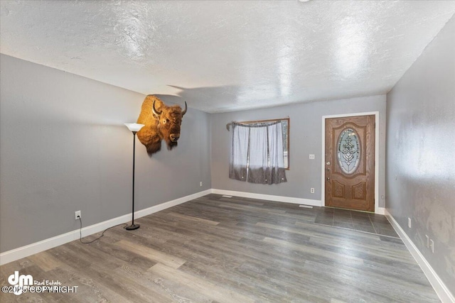 foyer with dark hardwood / wood-style flooring and a textured ceiling