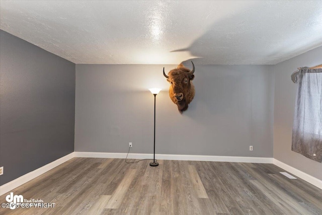 spare room with dark hardwood / wood-style flooring and a textured ceiling