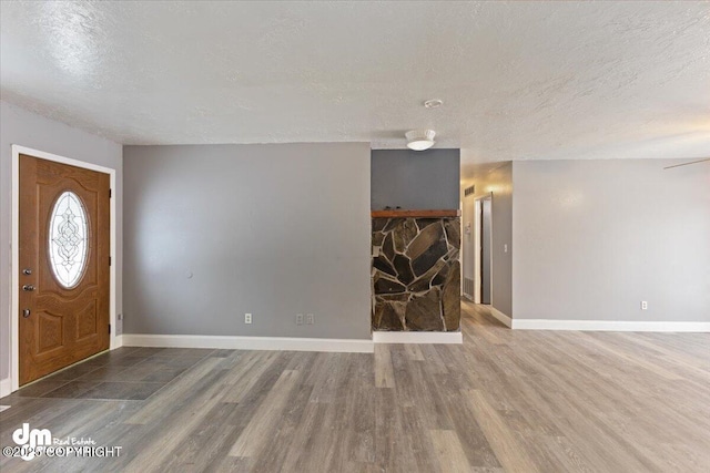 foyer entrance with wood-type flooring and a textured ceiling