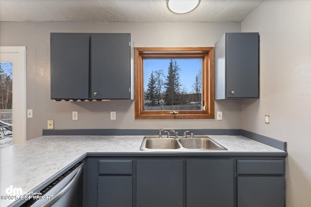 kitchen featuring gray cabinets, sink, dishwasher, and a textured ceiling