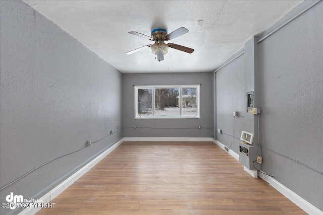 spare room featuring ceiling fan, a textured ceiling, and light wood-type flooring