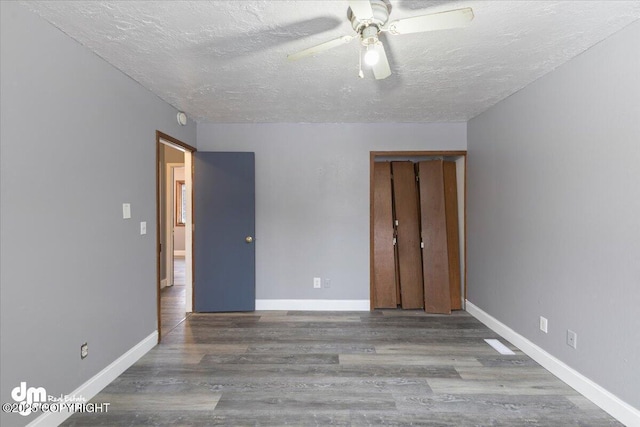 unfurnished bedroom featuring hardwood / wood-style flooring, a textured ceiling, and ceiling fan