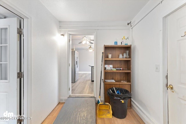 hallway featuring a textured ceiling and light hardwood / wood-style floors