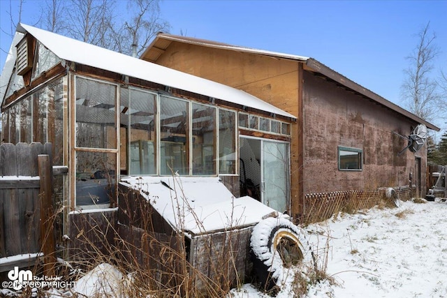 view of snow covered exterior featuring a sunroom